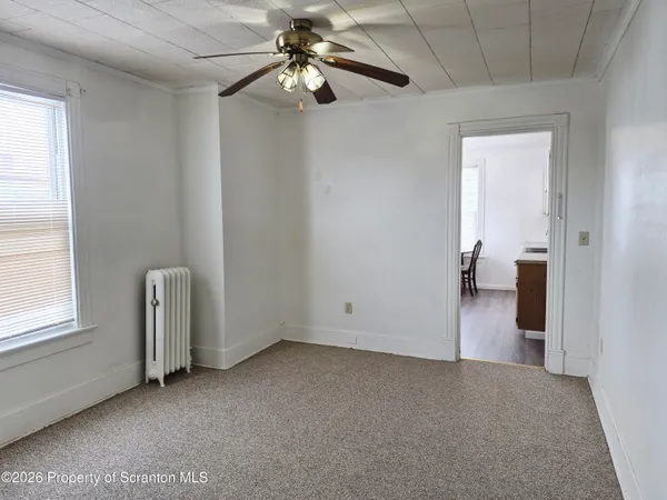 an empty room with a ceiling fan and a window