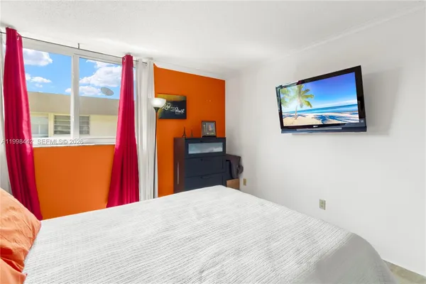 a bedroom with a bed and a painting on the wall