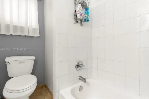 a white toilet sitting next to a bath tub