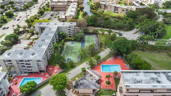 an aerial view of residential houses with outdoor space and trees