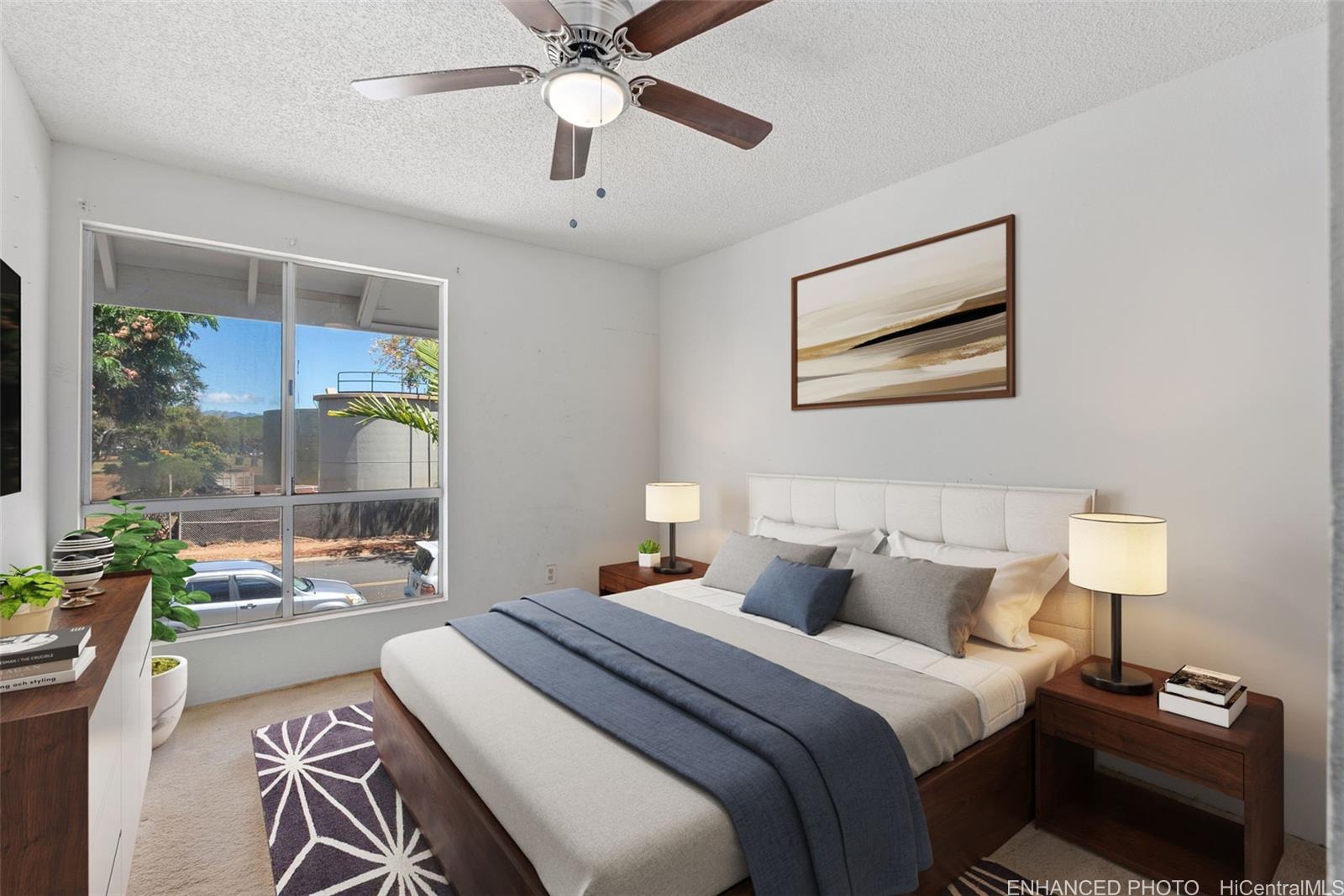 94-201 Lumiaina Place, Unit E202 Waipahu, HI 96797 - Photo 11 of 25 a bedroom with a bed and a chandelier