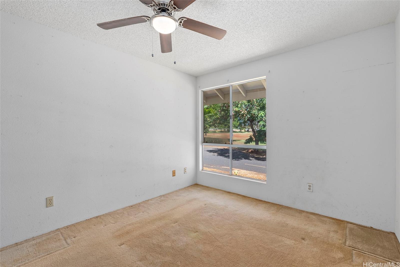 94-201 Lumiaina Place, Unit E202 Waipahu, HI 96797 - Photo 14 of 25 an empty room with a ceiling fan and window