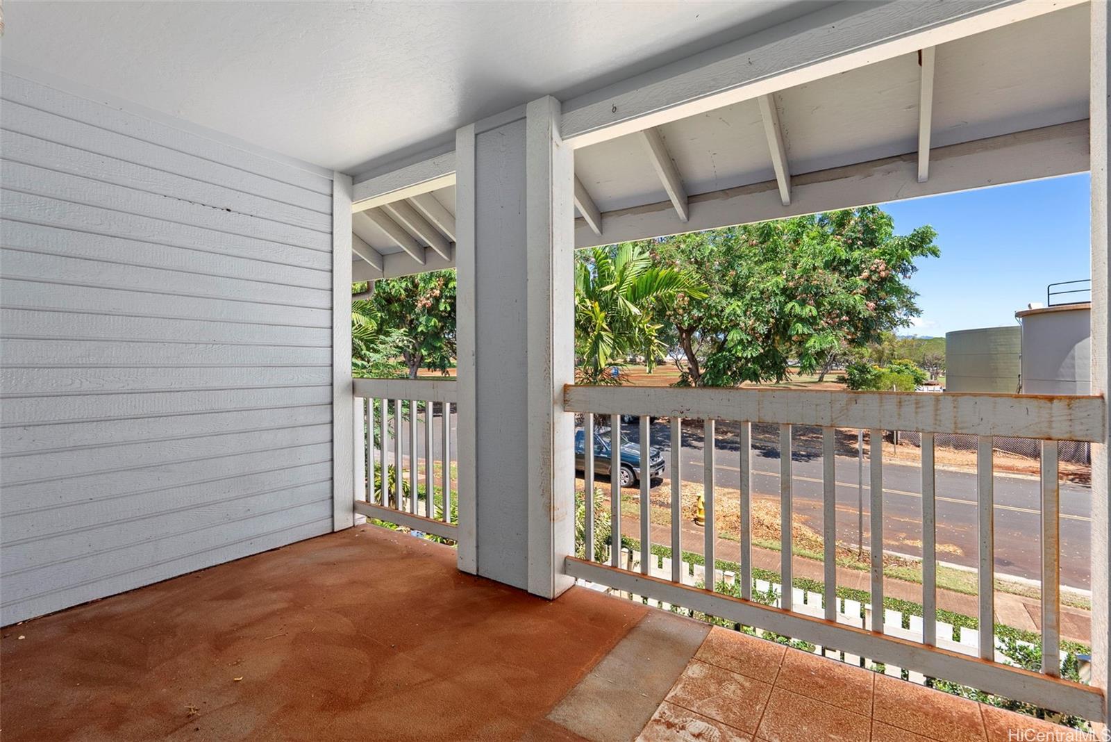 94-201 Lumiaina Place, Unit E202 Waipahu, HI 96797 - Photo 20 of 25 a view of a balcony with a floor to ceiling window and wooden fence