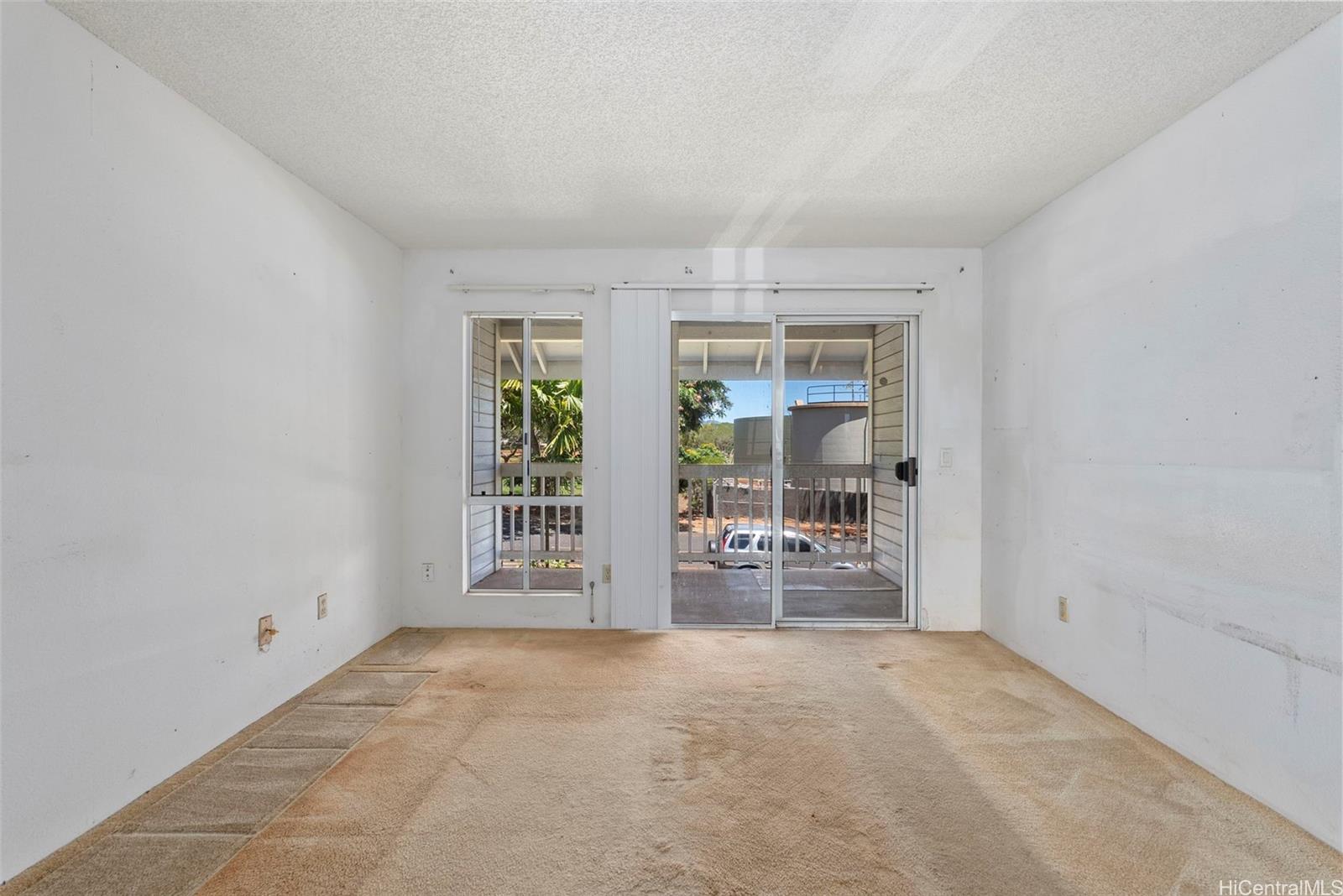 94-201 Lumiaina Place, Unit E202 Waipahu, HI 96797 - Photo 6 of 25 an empty room with windows and cabinet