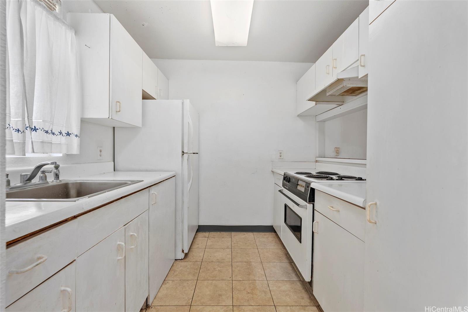 94-201 Lumiaina Place, Unit E202 Waipahu, HI 96797 - Photo 7 of 25 a kitchen with a sink stove and cabinets