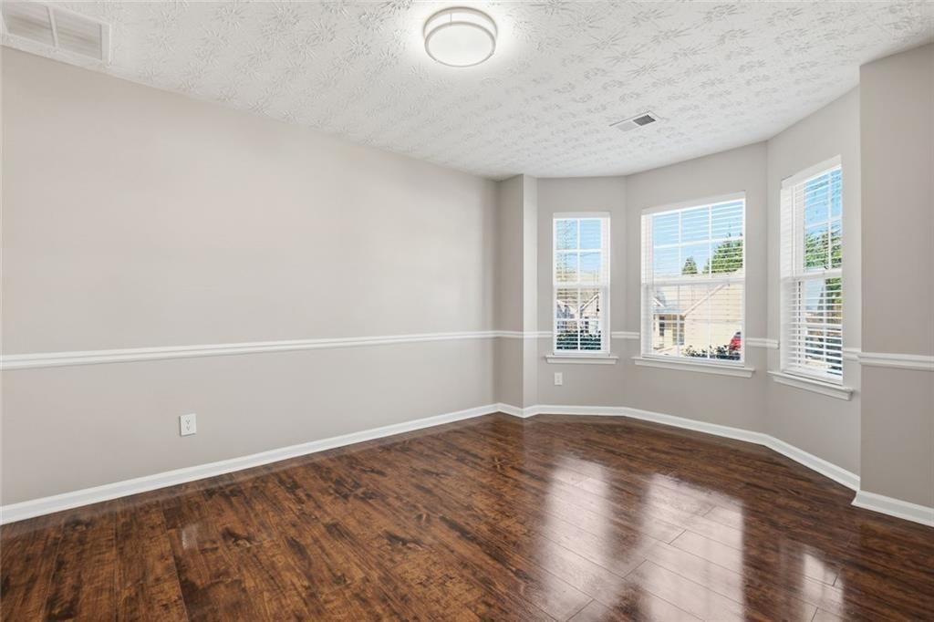 3570 Bogan Mill Road Northeast Buford, GA 30519 - Photo 11 of 31 an empty room with wooden floor and windows
