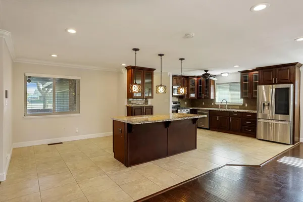 a front view of a house with a garden and trees