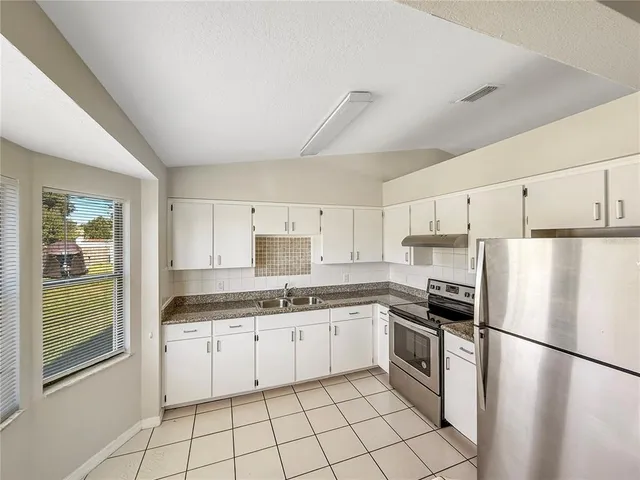 a kitchen with white cabinets and white appliances