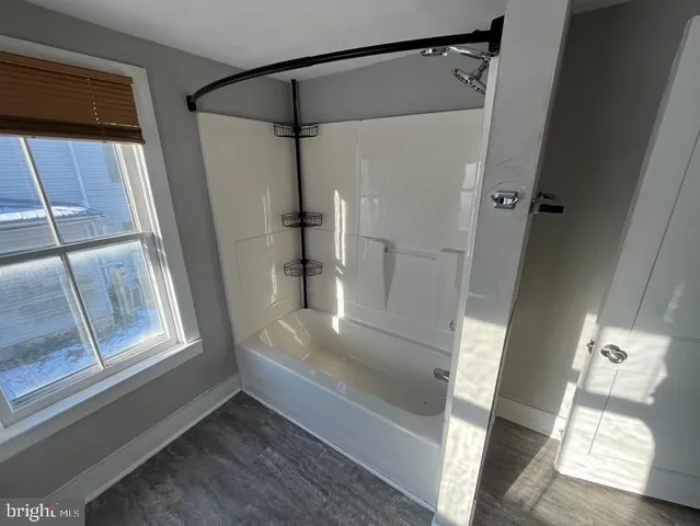 a view of walk in closet with wooden floor and windows