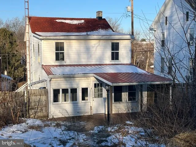 a view of a white house with a yard and balcony