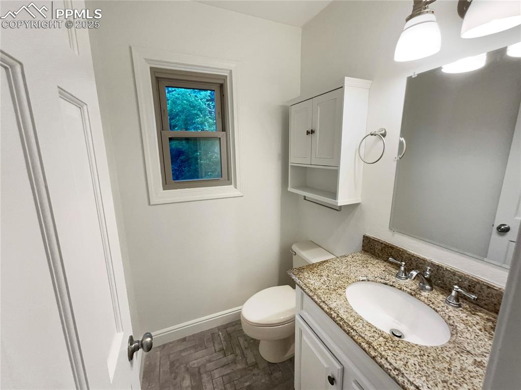 570 Ore Cart Way Monument, CO 80132 - Photo 12 of 22 a bathroom with a granite countertop sink toilet and mirror