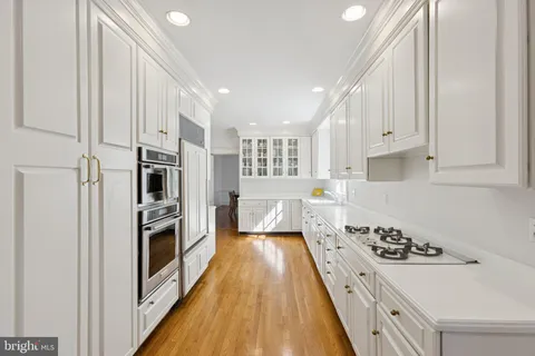 a kitchen with stainless steel appliances a refrigerator a stove and wooden floor