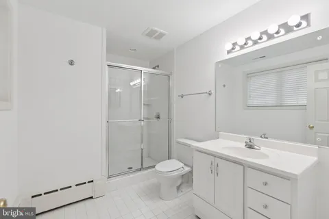 a bathroom with a toilet a sink a mirror and vanity
