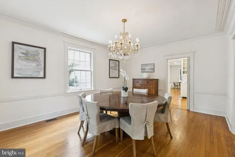 a view of a dining room with furniture wooden floor and a chandelier