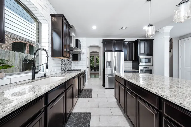 a kitchen with stainless steel appliances granite countertop a stove a sink a refrigerator and a oven