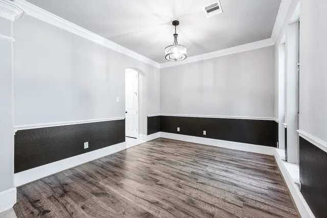 a view of an empty room with wooden floor fireplace and a window