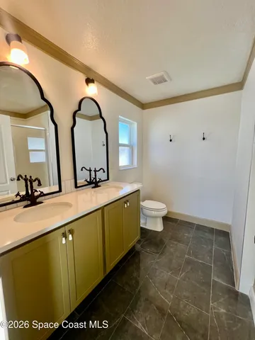 an empty room with wooden floor cabinet and windows