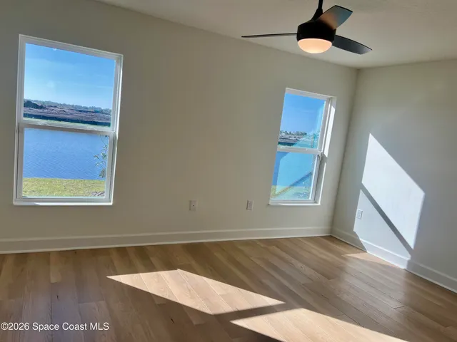 an empty room with wooden floor and window