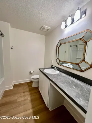 a bathroom with a granite countertop toilet sink and mirror