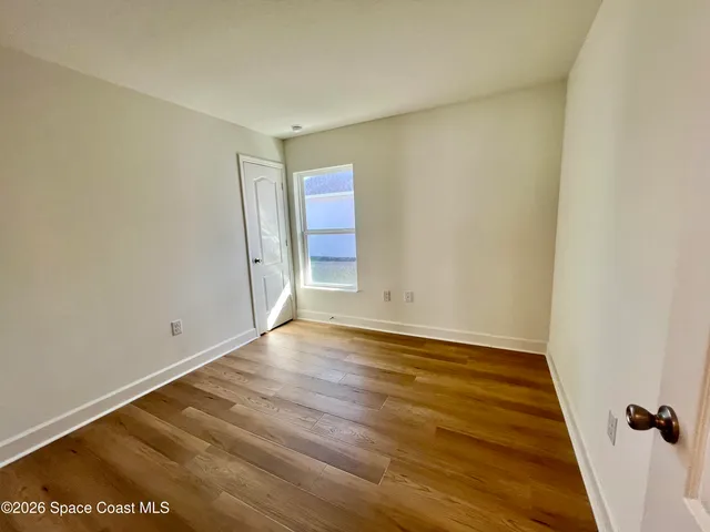 a view of a livingroom with a chandelier fan and wooden floor