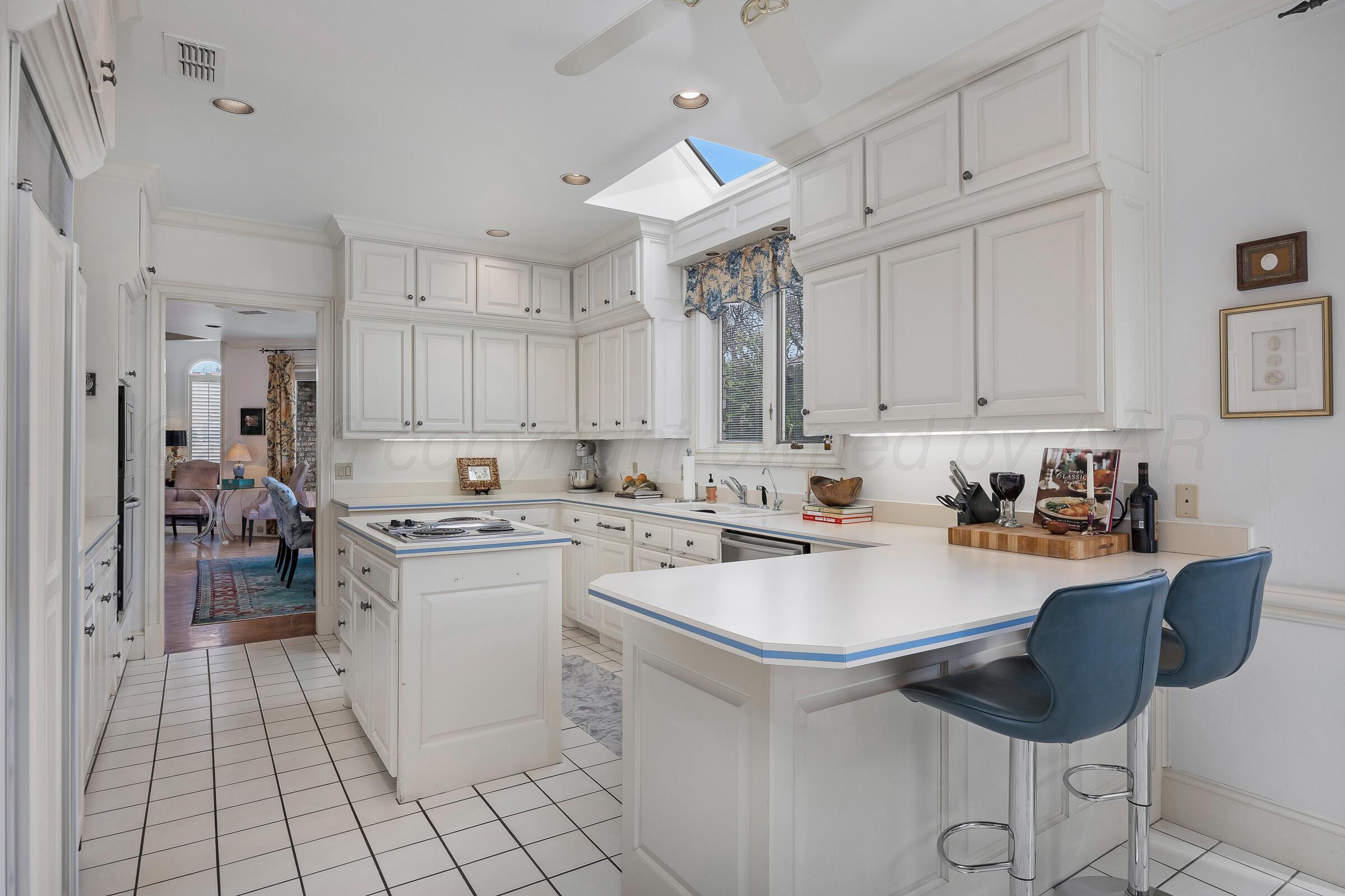 1 Gunn Court Amarillo, TX 79106 - Photo 12 of 36 a kitchen with a sink a stove cabinets and dining table chair