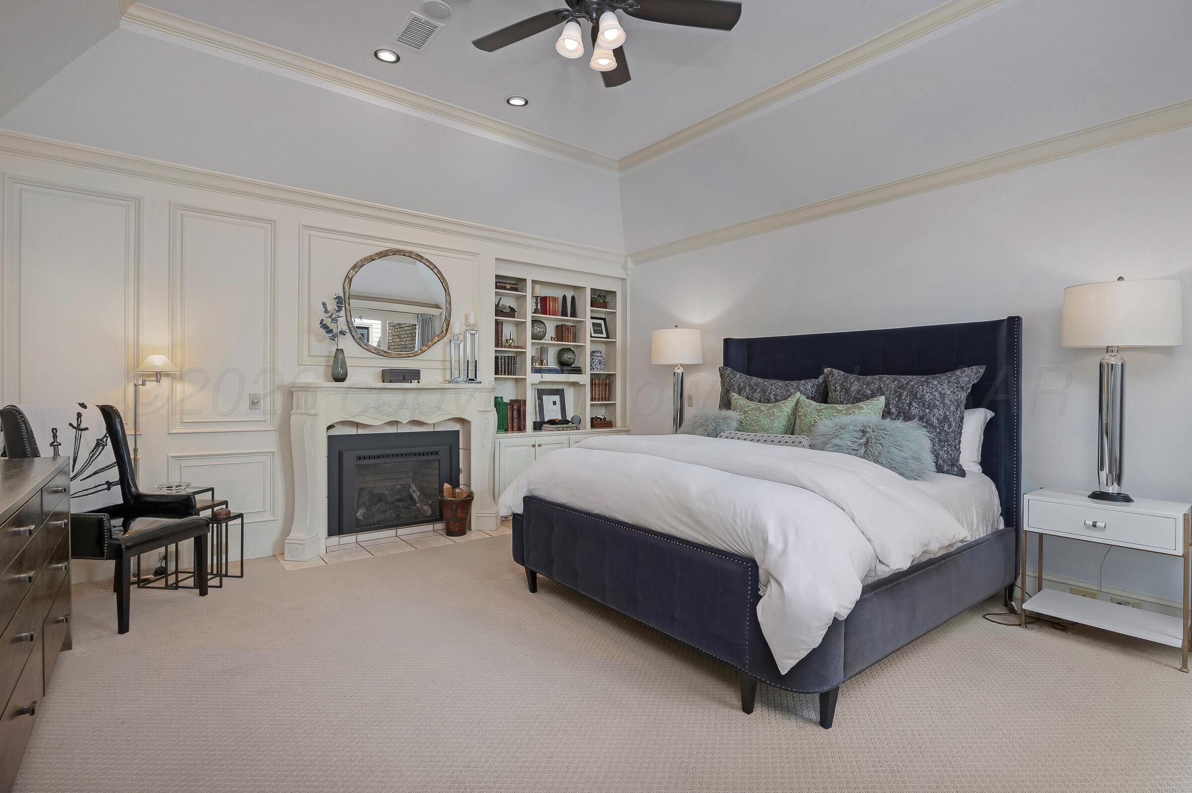 1 Gunn Court Amarillo, TX 79106 - Photo 21 of 36 a spacious bedroom with a bed and a fireplace