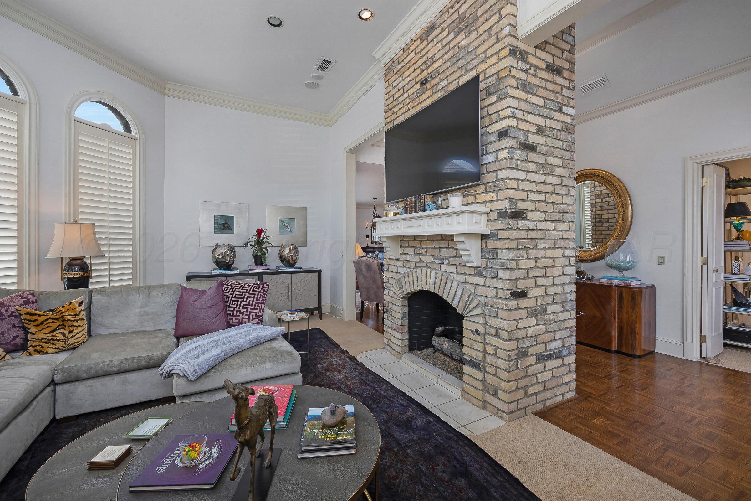 1 Gunn Court Amarillo, TX 79106 - Photo 8 of 36 a living room with furniture a flat screen tv and a fireplace