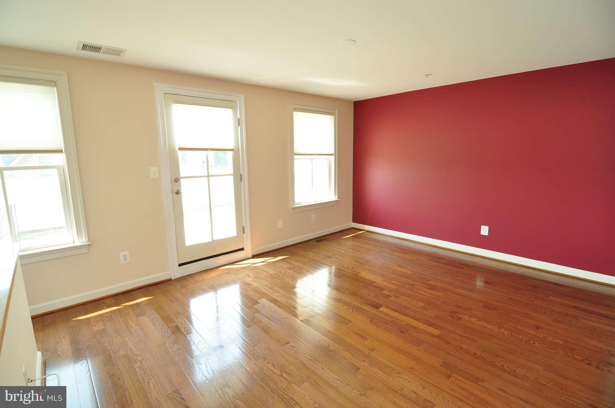 719 Carpenter Road Alexandria, VA 22314 - Photo 15 of 26 an empty room with wooden floor and windows with curtains