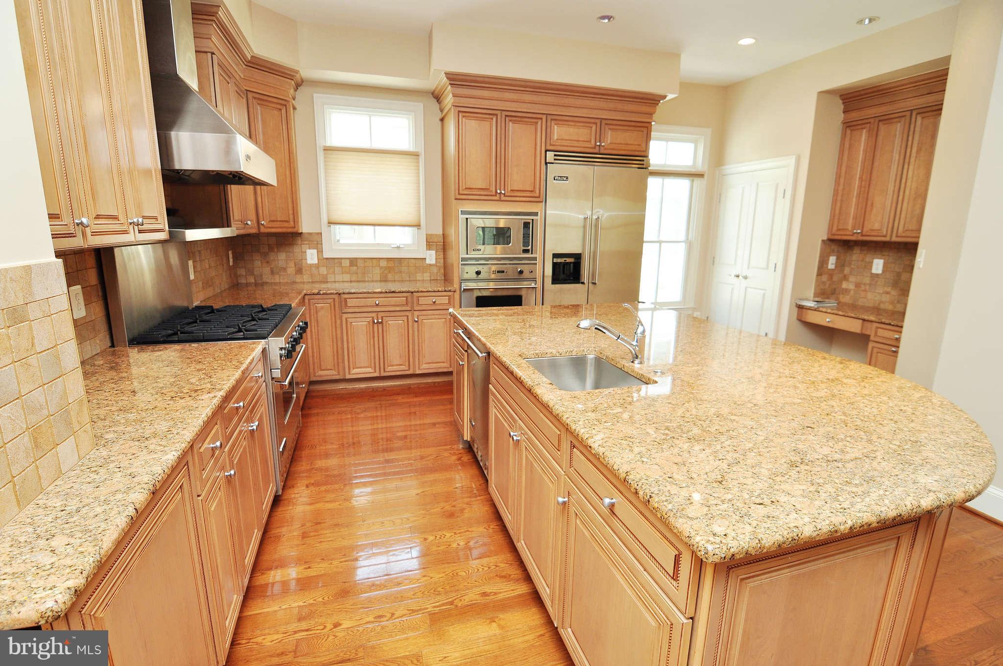 719 Carpenter Road Alexandria, VA 22314 - Photo 5 of 26 a large kitchen with kitchen island a sink stove and wooden cabinets