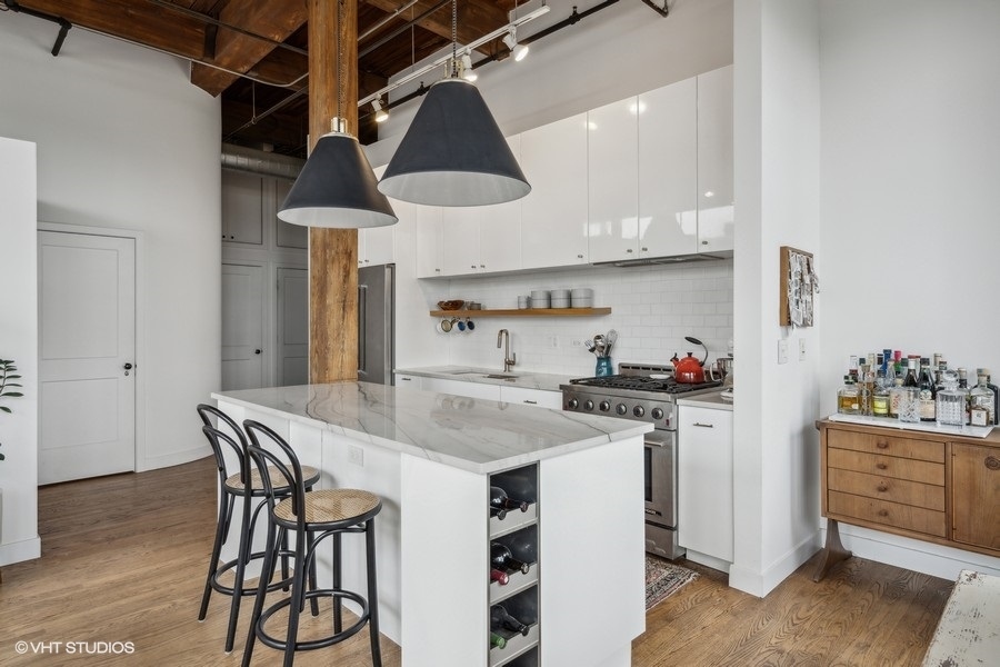 1500 West Monroe Street, Unit 425 Chicago, IL 60607 - Photo 9 of 33 a kitchen with stainless steel appliances a table a stove a chimney a sink and cabinets