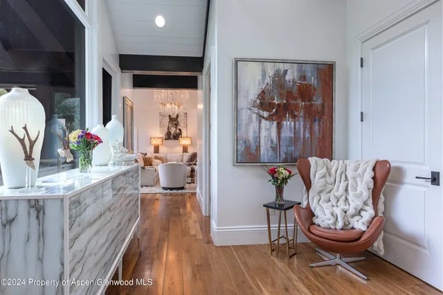 a view of a hallway with wooden floor and a bathroom