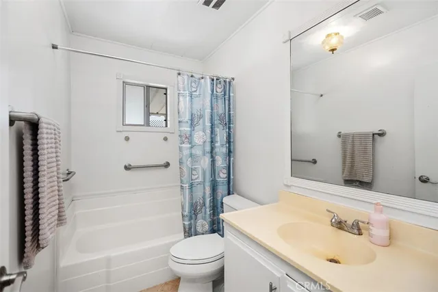 a bathroom with a sink toilet vanity and shower