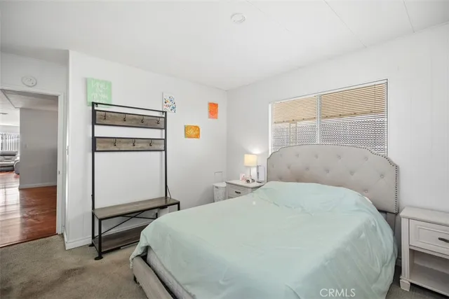 a bedroom with a bed and a refrigerator