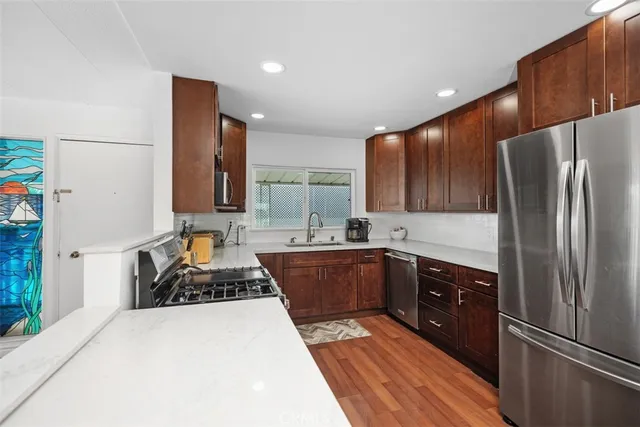 a kitchen with stainless steel appliances a refrigerator sink and stove