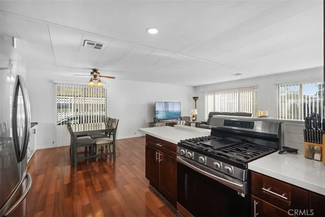 a kitchen with a stove and wooden floor