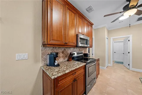 a kitchen with stainless steel appliances a dining table chairs and a chandelier