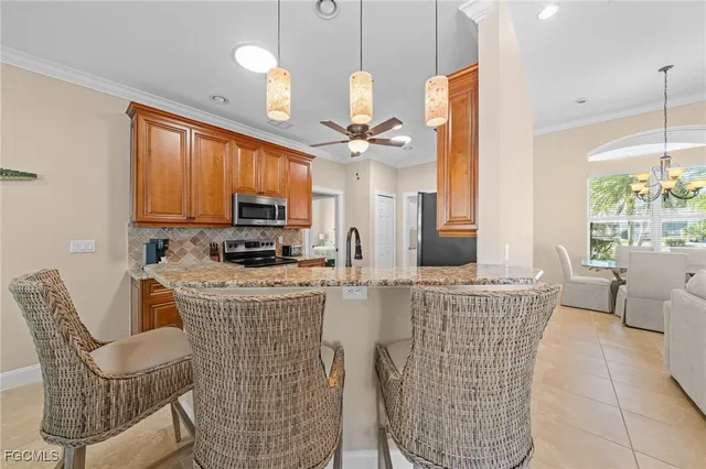 a kitchen with stainless steel appliances a dining table chairs and a chandelier