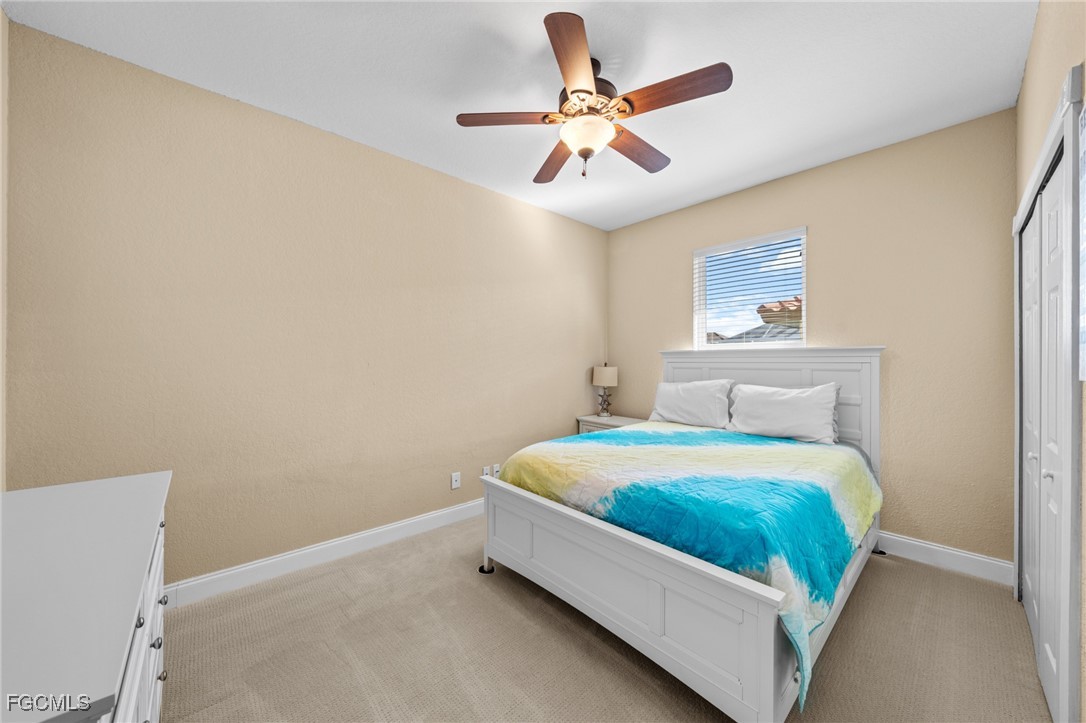 5025 Southwest 10th Avenue Cape Coral, FL 33914 - Photo 28 of 44 a bedroom with a bed and a ceiling fan