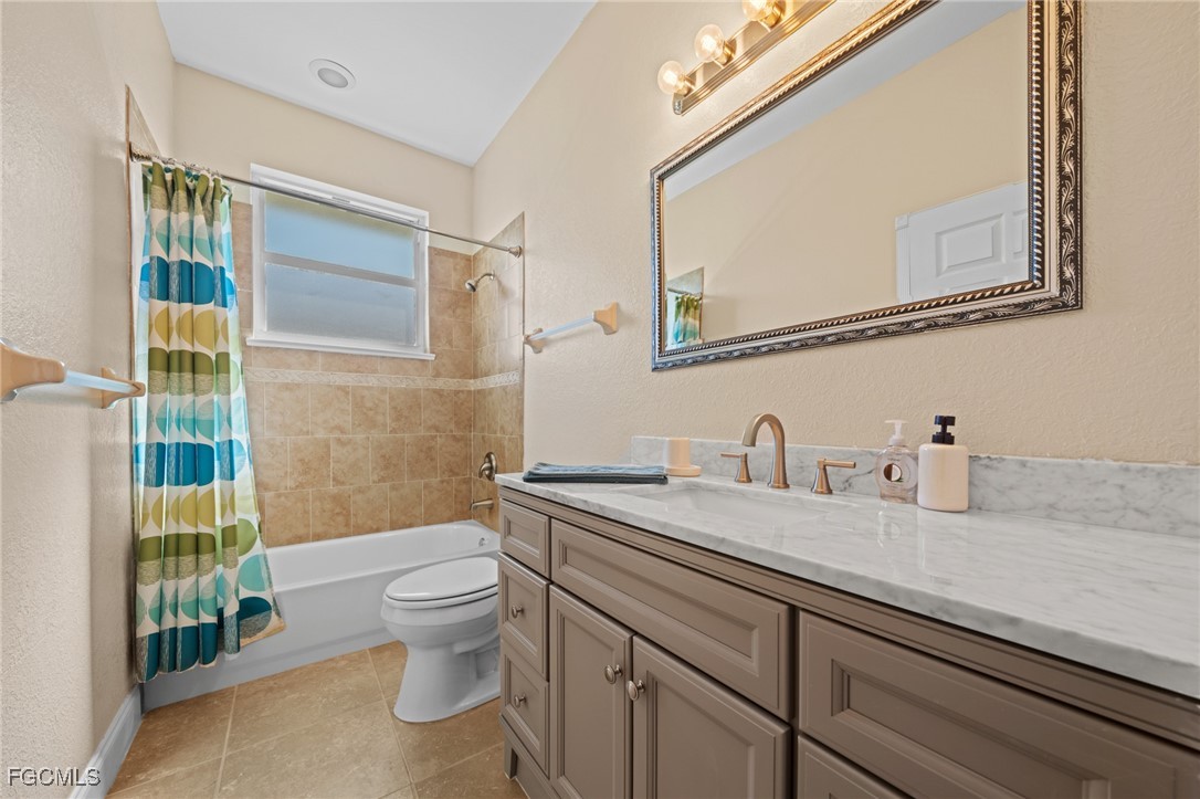 5025 Southwest 10th Avenue Cape Coral, FL 33914 - Photo 29 of 44 a bathroom with a granite countertop toilet sink and mirror