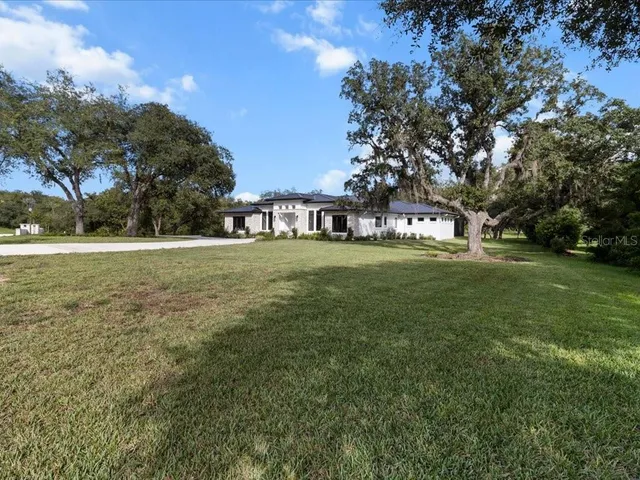an aerial view of a house with a yard basket ball court and outdoor seating