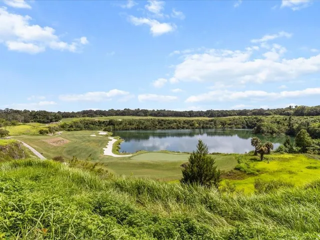 a view of a lake with a yard from a balcony