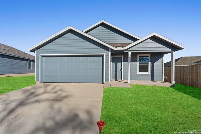 a front view of a house with yard and garage