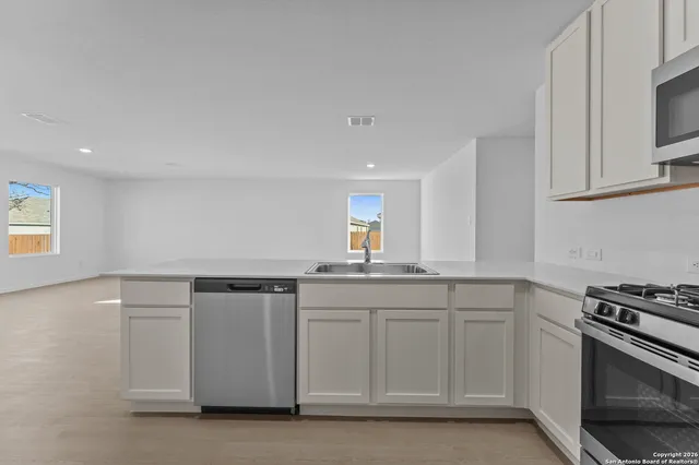 a kitchen with granite countertop white cabinets and stainless steel appliances