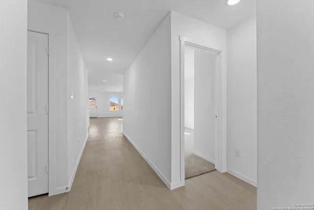 a view of a hallway with white walls and stairs