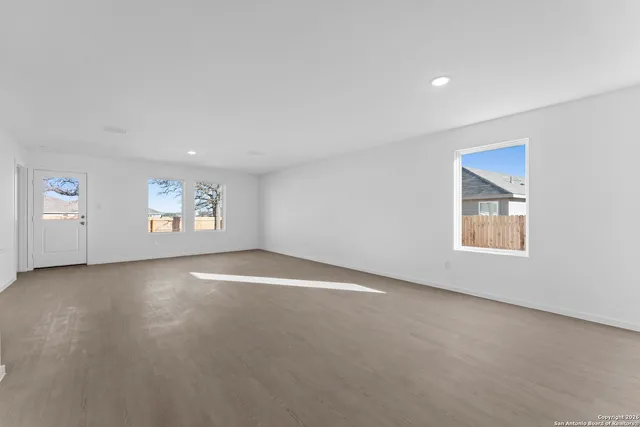 an empty room with a window and a ceiling fan