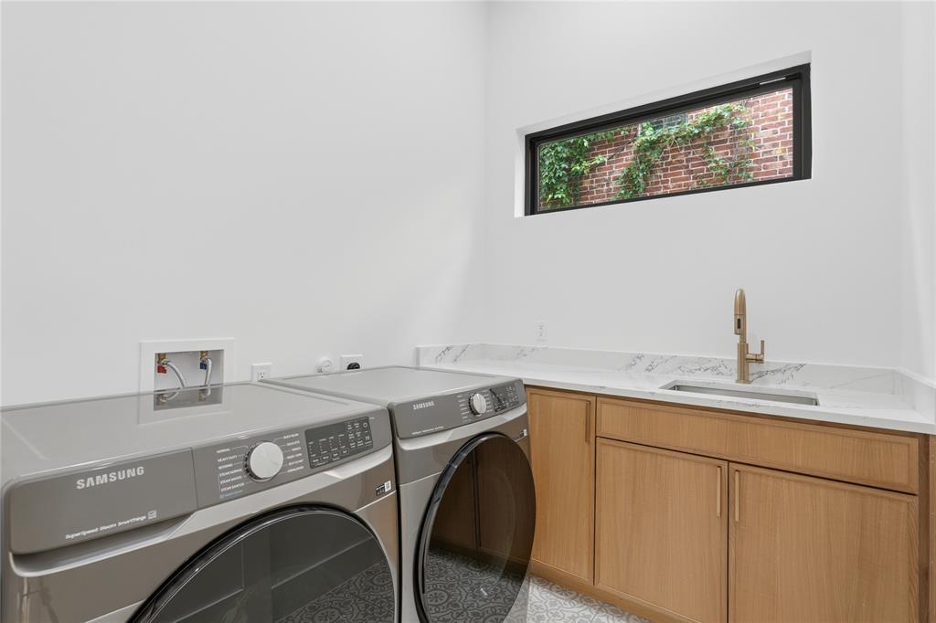 6038 Prospect Avenue Dallas, TX 75206 - Photo 12 of 40 Utility room featuring wood-finish cabinetry, a single basin sink with a gold-tone faucet, and a horizontally oriented window