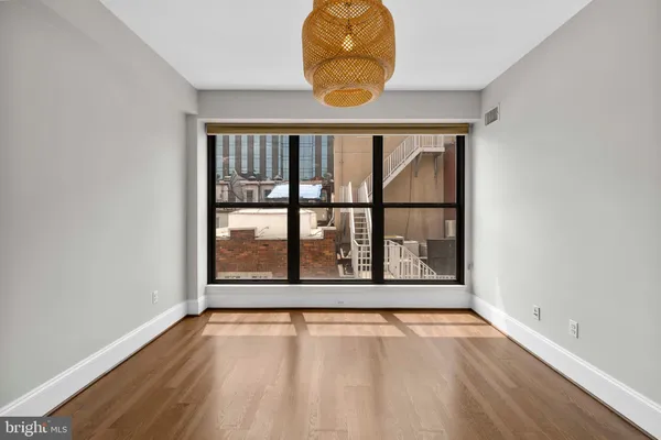 an empty room with wooden floor and a window