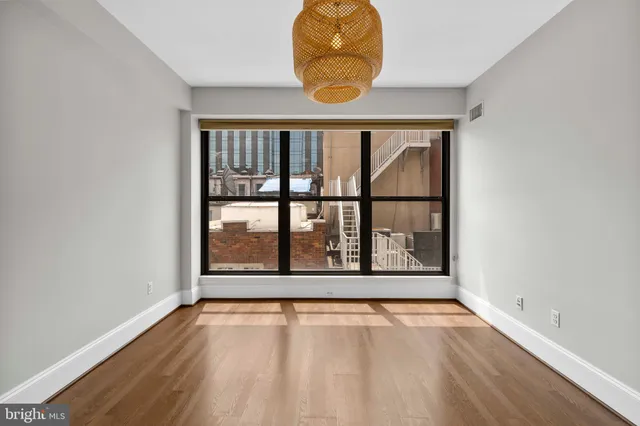 an empty room with wooden floor and a window