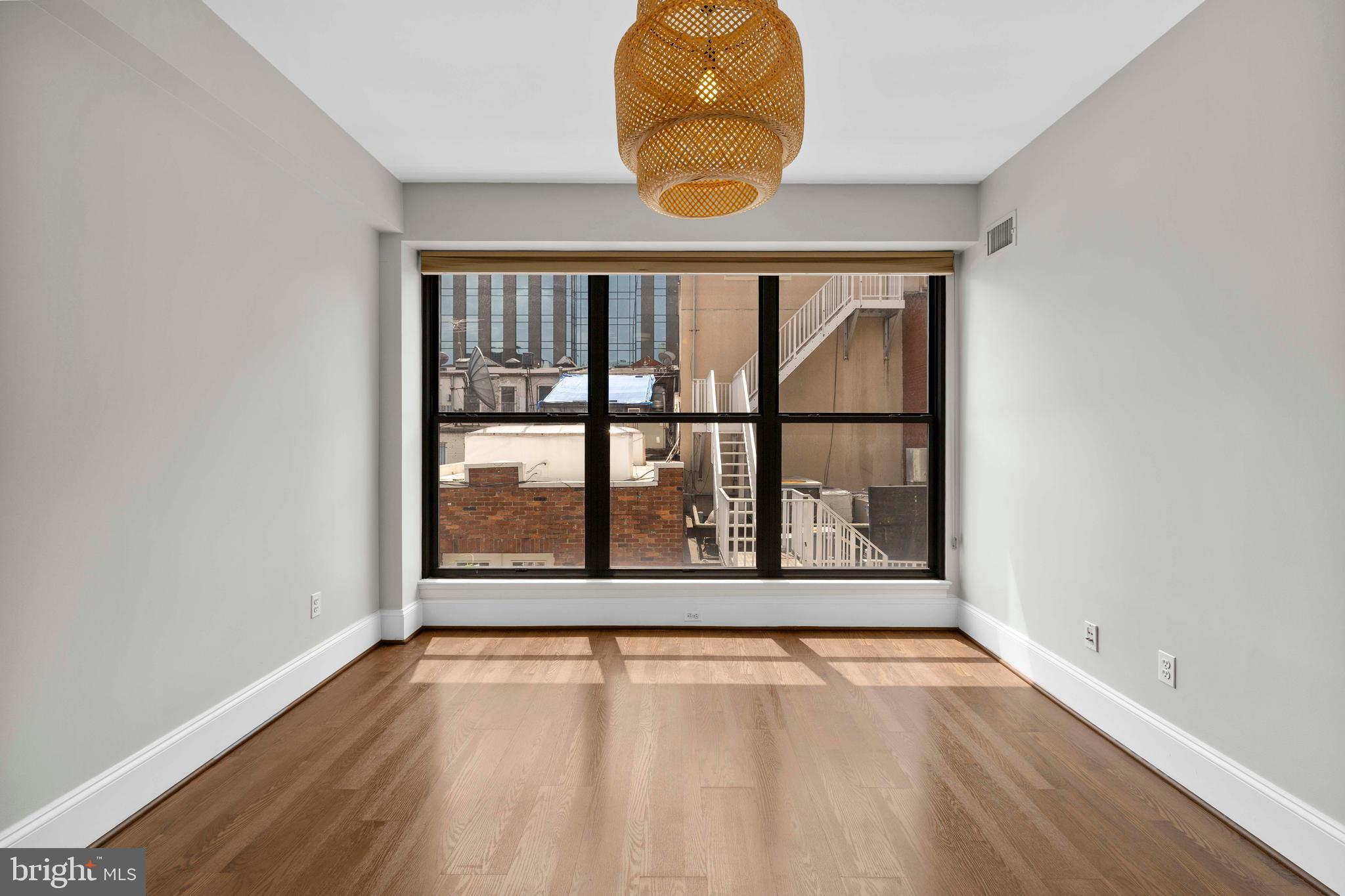 1830 Jefferson Place Northwest, Unit 12 Washington, DC 20036 - Photo 11 of 27 an empty room with wooden floor and a window
