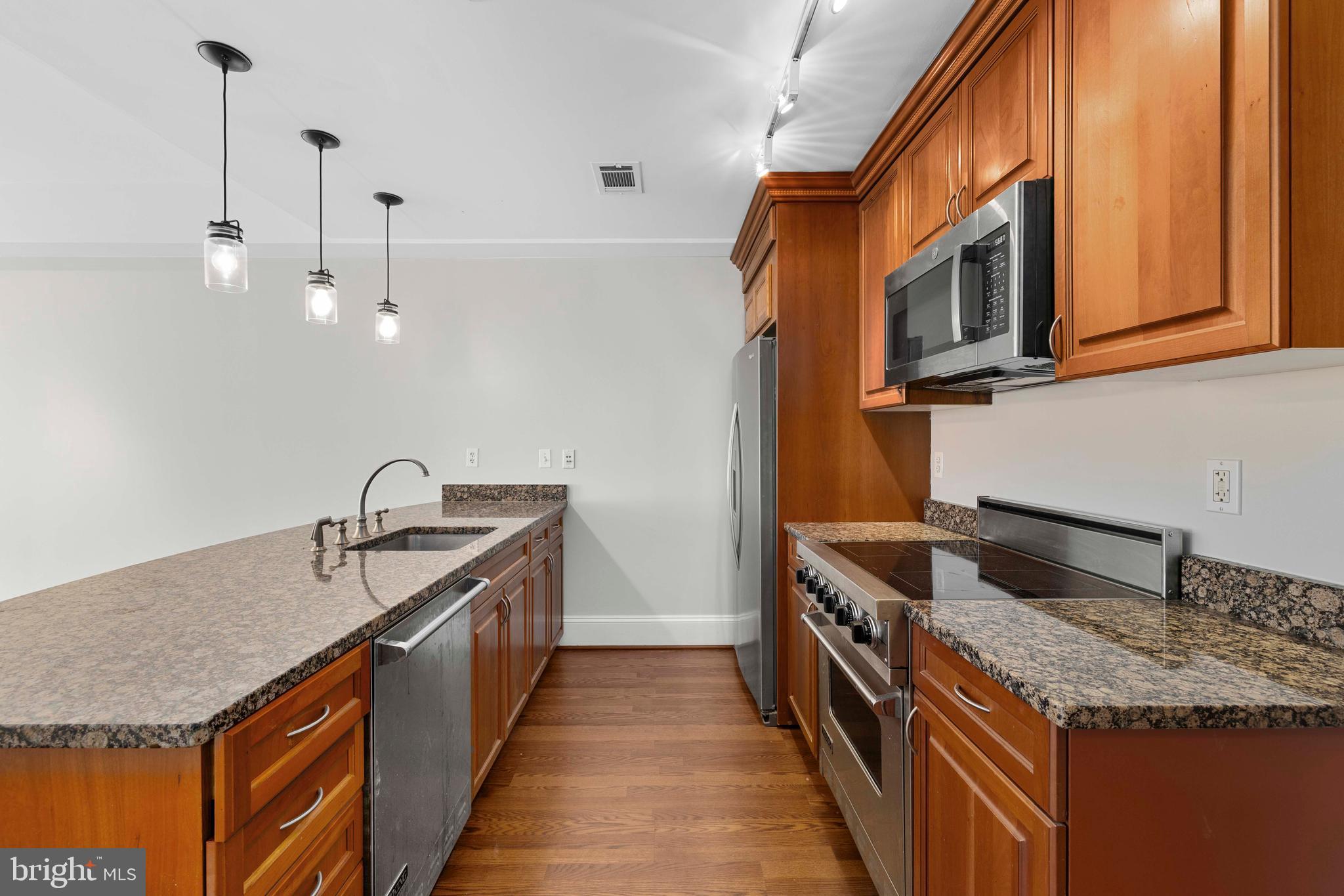 1830 Jefferson Place Northwest, Unit 12 Washington, DC 20036 - Photo 4 of 27 a kitchen with stainless steel appliances granite countertop a sink a stove and a wooden floor